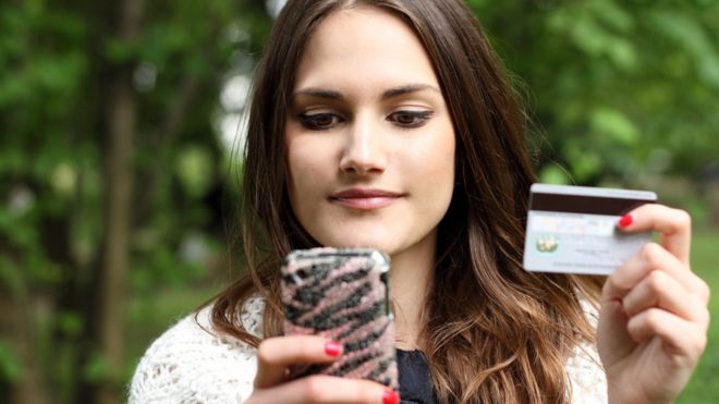 Young woman with smartphone and payment card