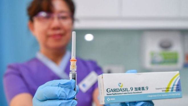 A doctor in China holding the Gardasil box