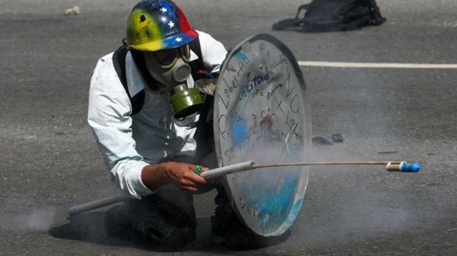 opositor venezolano con un escudo de lata