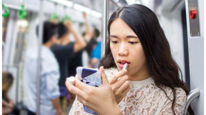Женщина наносит макияж в поезде