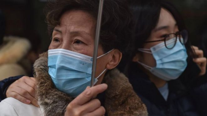 People wearing protective masks are seen outside a hospital in Shanghai on January 22, 2020