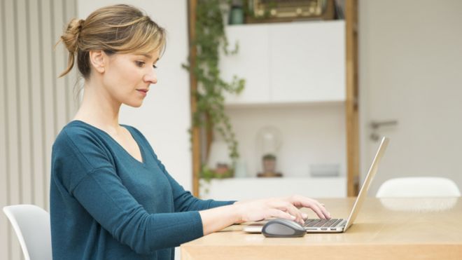 Общий образ женщины, работающей на ноутбуке дома