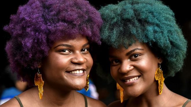 Две женщины с ярко окрашенными афро волосами