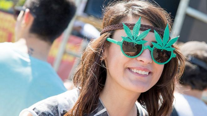 Mulher usando óculos com folha de maconha