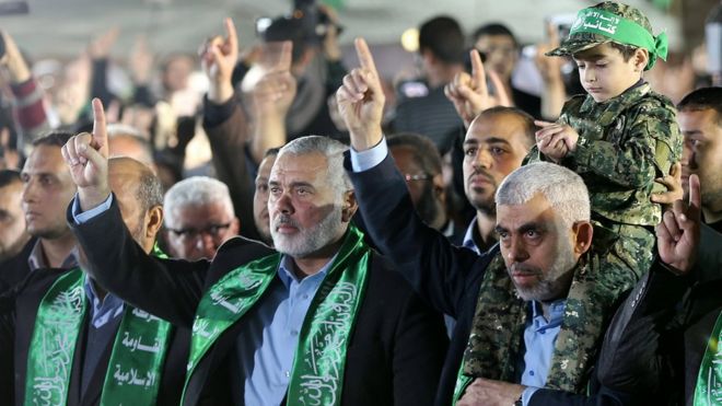 Новый лидер движения ХАМАС в секторе Газа Яхья Синвар (справа) держит на плечах сына Мазена Фукаха у мемориала (27 марта 2017 года)