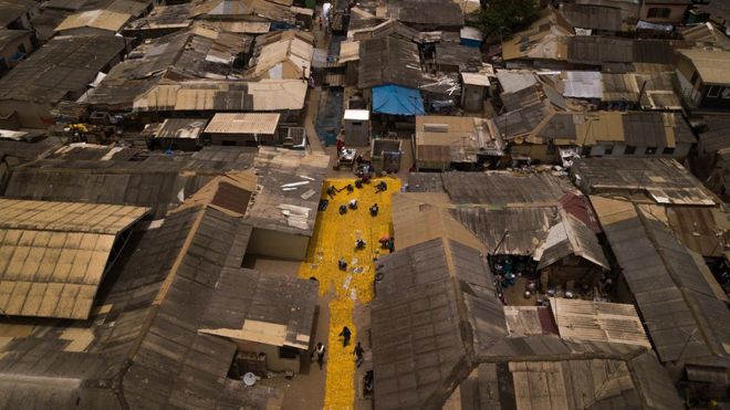 Воздушная съемка желтого гобелена, созданного художником Сержем Аттуквеем Клотти на дорогах в Ла - Аккре, Гана