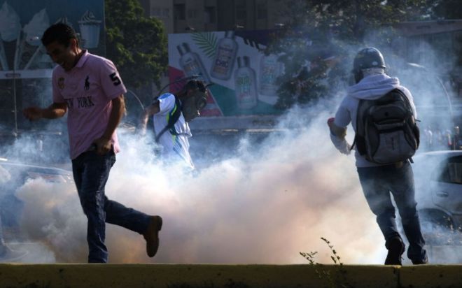 Manifestantes huyen de gases lacrimógenos