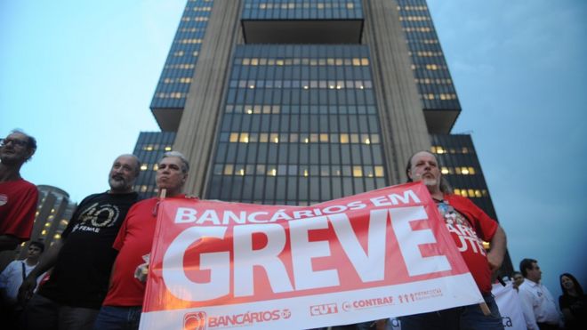 Bancários erguem cartaz de greve em frente a sede do Banco Central, em Brasília, em 2014