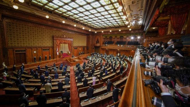 Photographers take photos of the session of hall of Japan's parliament.