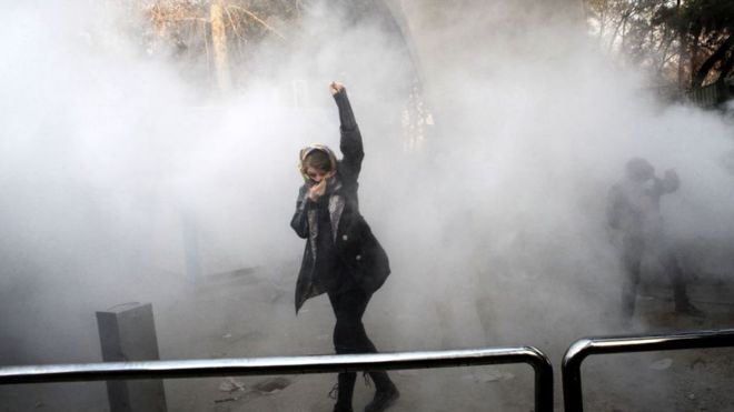Una joven en medio del gas lacrimógeno