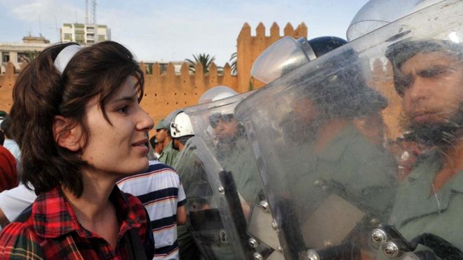 Мирные протесты с большей долей вероятности привлекают на свою сторону население. На снимке - участница демонстрации в поддержку реформ перед бойцами сил безопасности в Марокко (2011 г.)