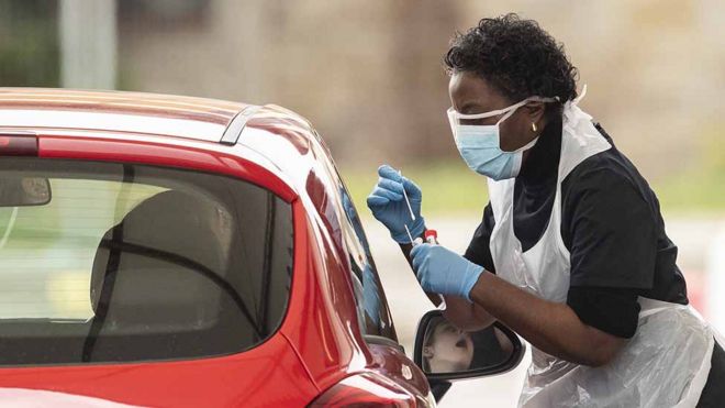 A nurse takes a swab at a Covid-19 Drive-Through testing station for NHS staff on March 30, 2020 in Chessington