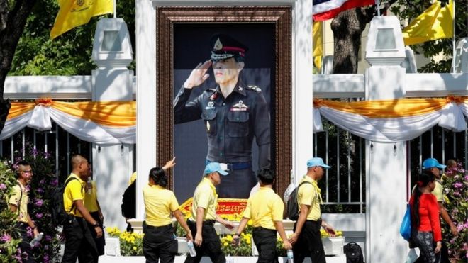 Люди идут перед портретом короля Таиланда Маха Ваджиралонгкорна во время репетиции его коронационного шествия, которое состоится на следующей неделе в Бангкоке, Таиланд, 28 апреля 2019 года.
