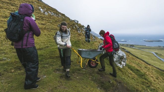 Члены Brown Group помогают друг другу толкать тачку в горах в Киркюбюре