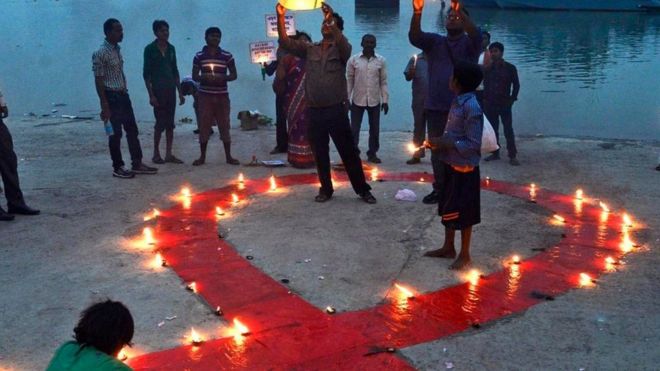 أشخاص يشعلون الشموع في اليوم العالمي للإيدز