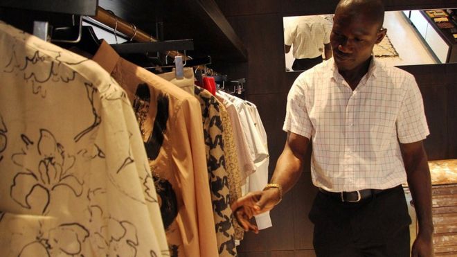 Мужчина смотрит на одежду в магазине в Лагосе, Нигерия