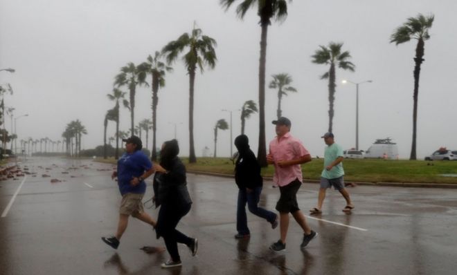 A group of people race across the street as winds from Hurricane Harvey escalated in Corpus Christi, Texas, U.S. August 25, 2017.