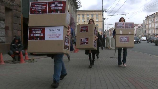 Правозащитники-геи несут пустые коробки в Генеральную прокуратуру.