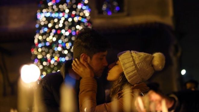 A couple kiss during a Christmas Eve ceremony at St Antuan Church in Istanbul, Turkey