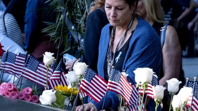 世界貿易センタービルへの攻撃で亡くなった夫の名前が刻まれた慰霊碑に触れる女性