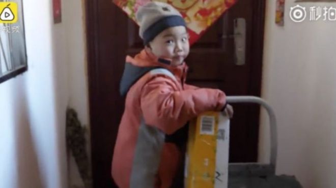 Seven-year-old Chang Jiang holding a parcel