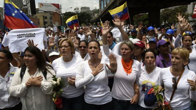 Экс-конгрессмен венесуэльской оппозиции Мария Корина Мачадо (C) принимает участие в женском марше, целью которого является оказание давления на президента Николаса Мадуро, авторитет которого все больше оспаривается в результате протестов и смертельных беспорядков в Каракасе
