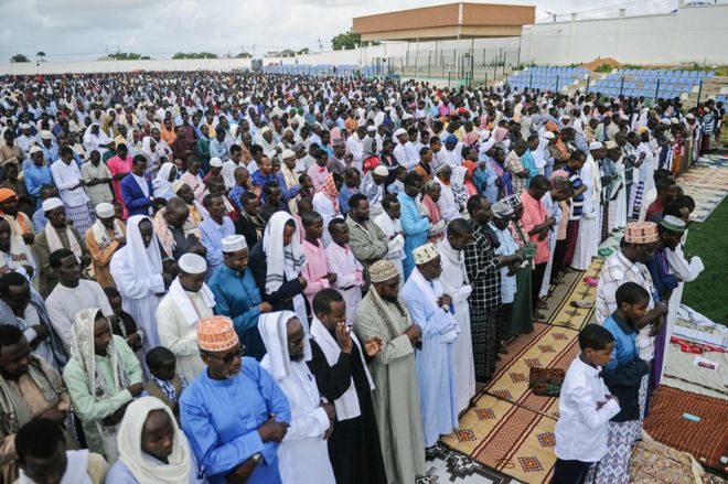 Сомалийские мусульмане принимают участие в молитве Ид аль-Фитр, посвященной окончанию священного месяца Рамадан на футбольном поле стадиона Джамакадаха в Могадишо, 15 июня 2018 года