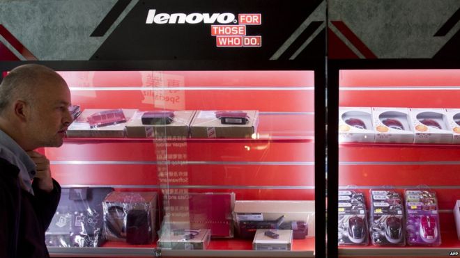 Человек проходит мимо рекламы китайского технологического гиганта Lenovo в Гонконге