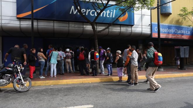 Люди в очереди возле банка в Каракасе, Венесуэла