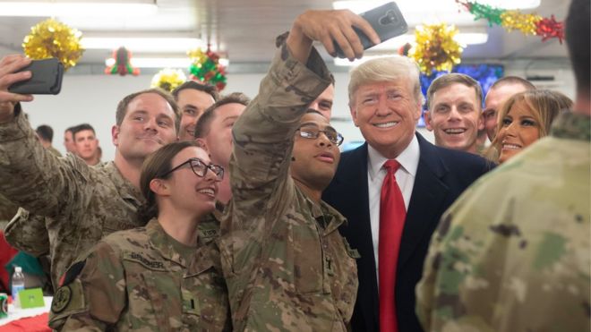 Президент США Дональд Трамп и первая леди Мелания Трамп приветствуют военнослужащих США во время необъявленной поездки на авиабазу Аль-Асад в Ираке 26 декабря 2018 года