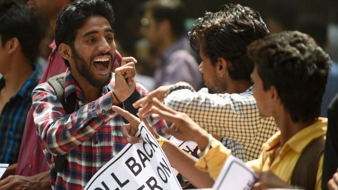 Индийские глухие активисты взаимодействуют с языком жестов во время акции протеста в Нью-Дели 5 мая 2015 года.