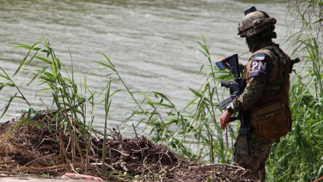 Un militar revisa las aguas de un río.