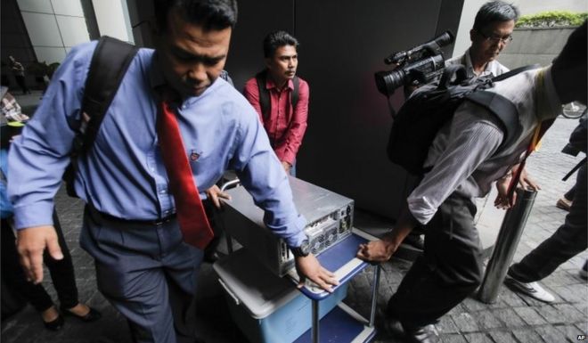 Полиция Малайзии в штатском носит компьютер из офиса 1MDB (1 Malaysia Development Berhad) после рейда в Куала-Лумпуре, Малайзия, 8 июля 2015 года