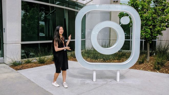 Мисс Вонг стоит рядом с логотипом Instagram