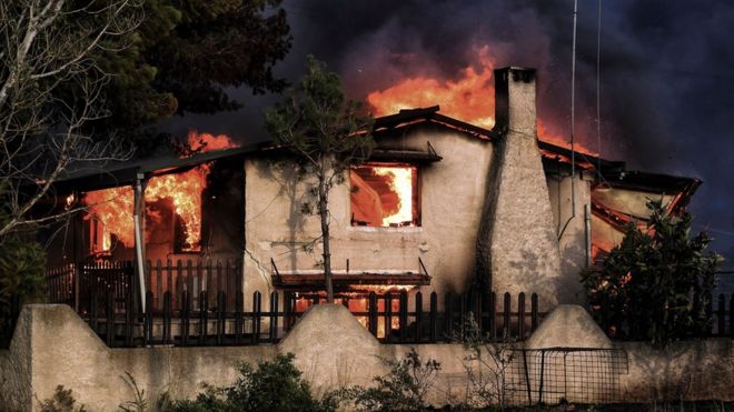 Дом горит во время пожара в Кинете, недалеко от Афин, 23 июля 2018 года
