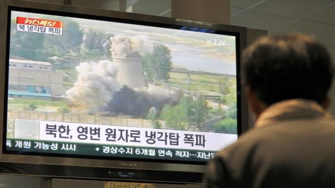 Южнокорейский смотрит кадры сноса градирни Северной Кореи на ее ядерном комплексе в Йонбене