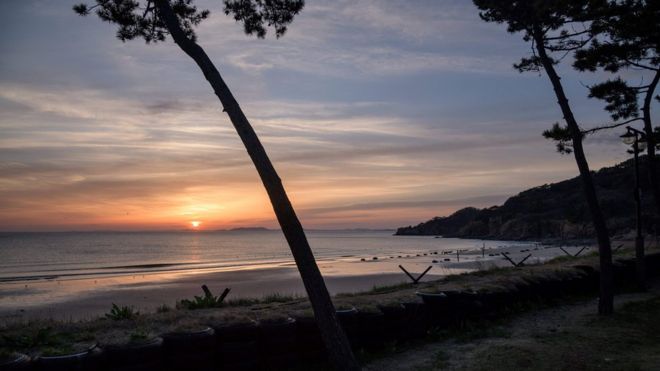 Солнце садится над Северной Кореей, если смотреть с берега Ёнпхён