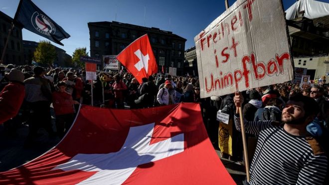 A protester holds up a banner reading in German 'freedom is unvaccinable' during a rally in opposition with the current measures to tackle the spread of the coronavirus, Covid-19 health pass and vaccination, in Bern on October 23, 2021