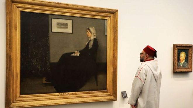 Марокканский король Мохаммед VI смотрит на картину Джеймса Эббота Макнил Уистлера (1871) «Мать Вистлера», когда он посещает музей Лувр Абу-Даби во время его открытия 8 ноября 2017 года на острове Саадият в столице эмирата