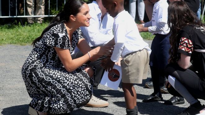Meghan speaks to a young boy on a visit to Cape Town's Nyanga township