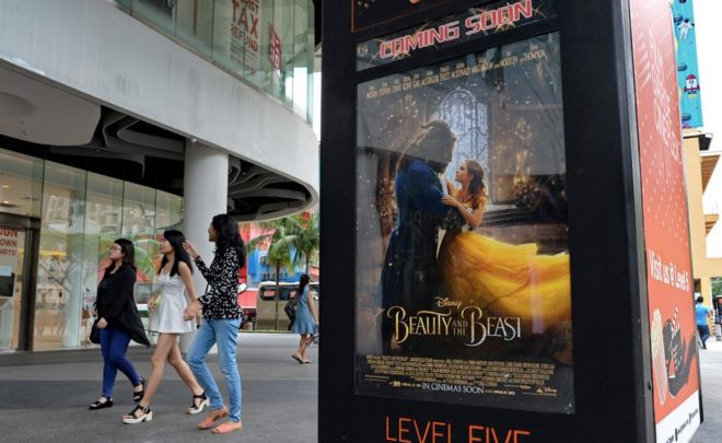 Люди проходят мимо плаката к фильму «Красавица и чудовище в Сингапуре» 14 марта 2017 года.