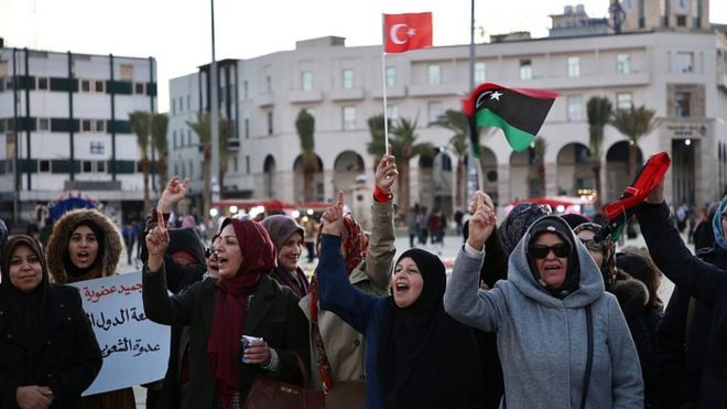 Libyans wave a Turkish and a national flag during a rally in support of the UN-recognised Tripoli-based government (GNA), in the capital Tripoli on January 3, 2020