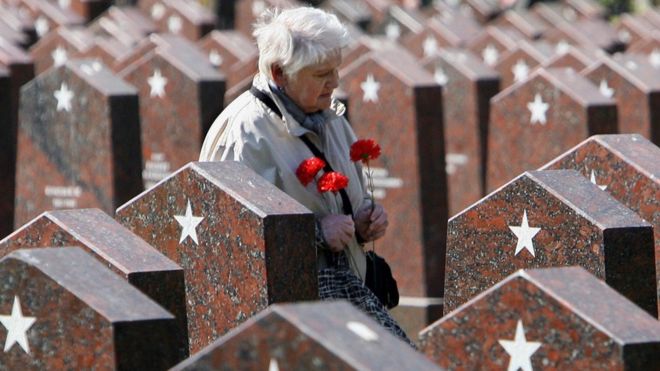 Женщина проходит мимо могил солдат, погибших во время Второй мировой войны, на кладбище в центре Москвы (8 мая 2006 года)