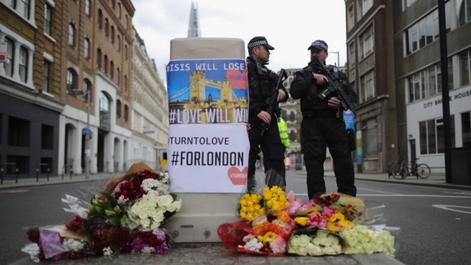 Homenaje a las víctimas con policías detrás en Londres.