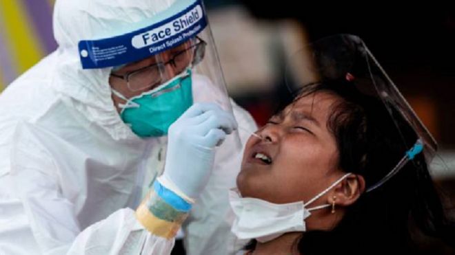 Medical officials conduct a nose swab test on a girl for the COVID-19 coronavirus at a seafood market in Samut Sakhon on December 19, 2020 after some new cases of local infections were detected and linked to a vendor at the market.