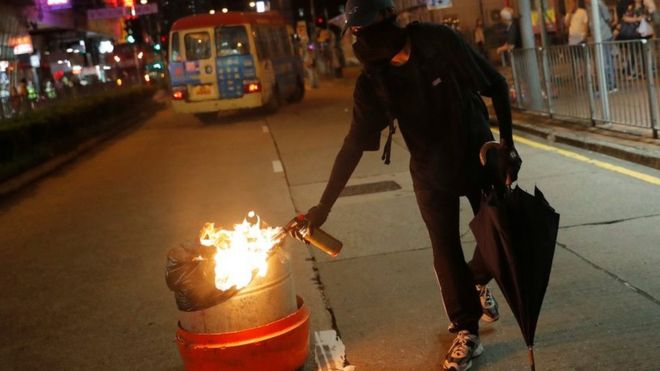 A demonstrator sets a bin on fire in Hong Kong
