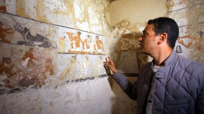 Египетский археолог указывает на настенные росписи внутри гробницы жрицы Старого Царства на плато Гиза на южной окраине Каира, Египет, 3 февраля 2018 года.