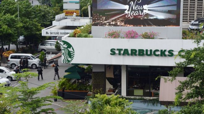 Индонезийская полиция охраняет территорию возле поврежденной кофейни Starbucks после серии взрывов, произошедших в центральной части Джакарты 14 января 2016 года