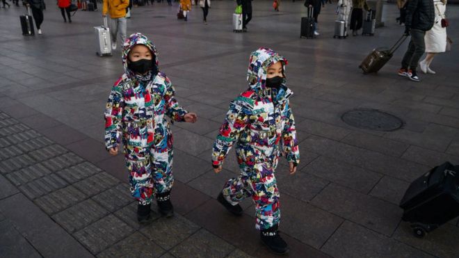 Twins wearing masks on a shopping street in Beijing