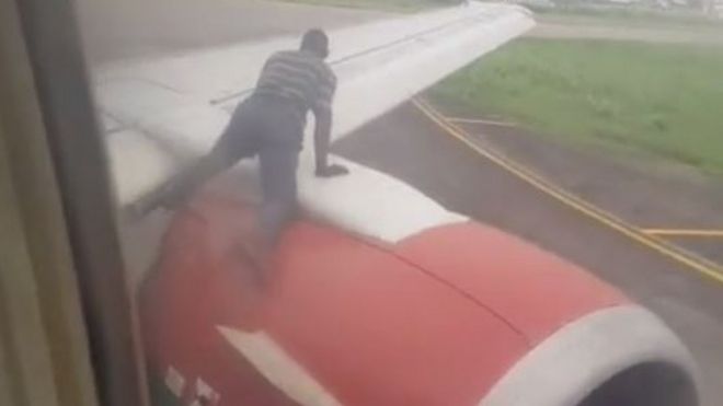uçağa tırmanmaya çalışan kişi